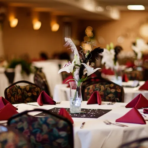 Banquet tables set with white linen and red napkins
