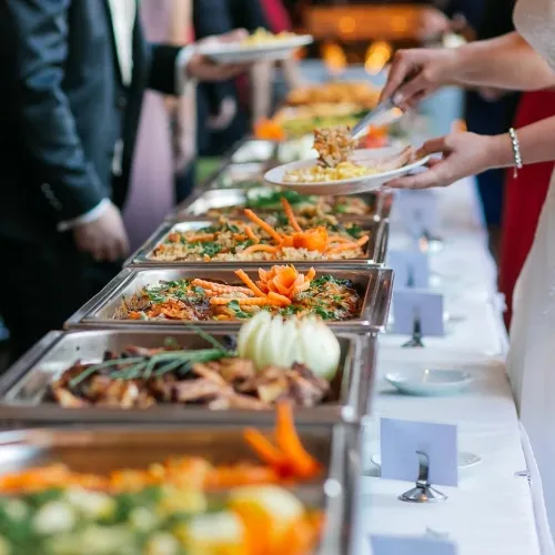 Guests being served from a long catering line